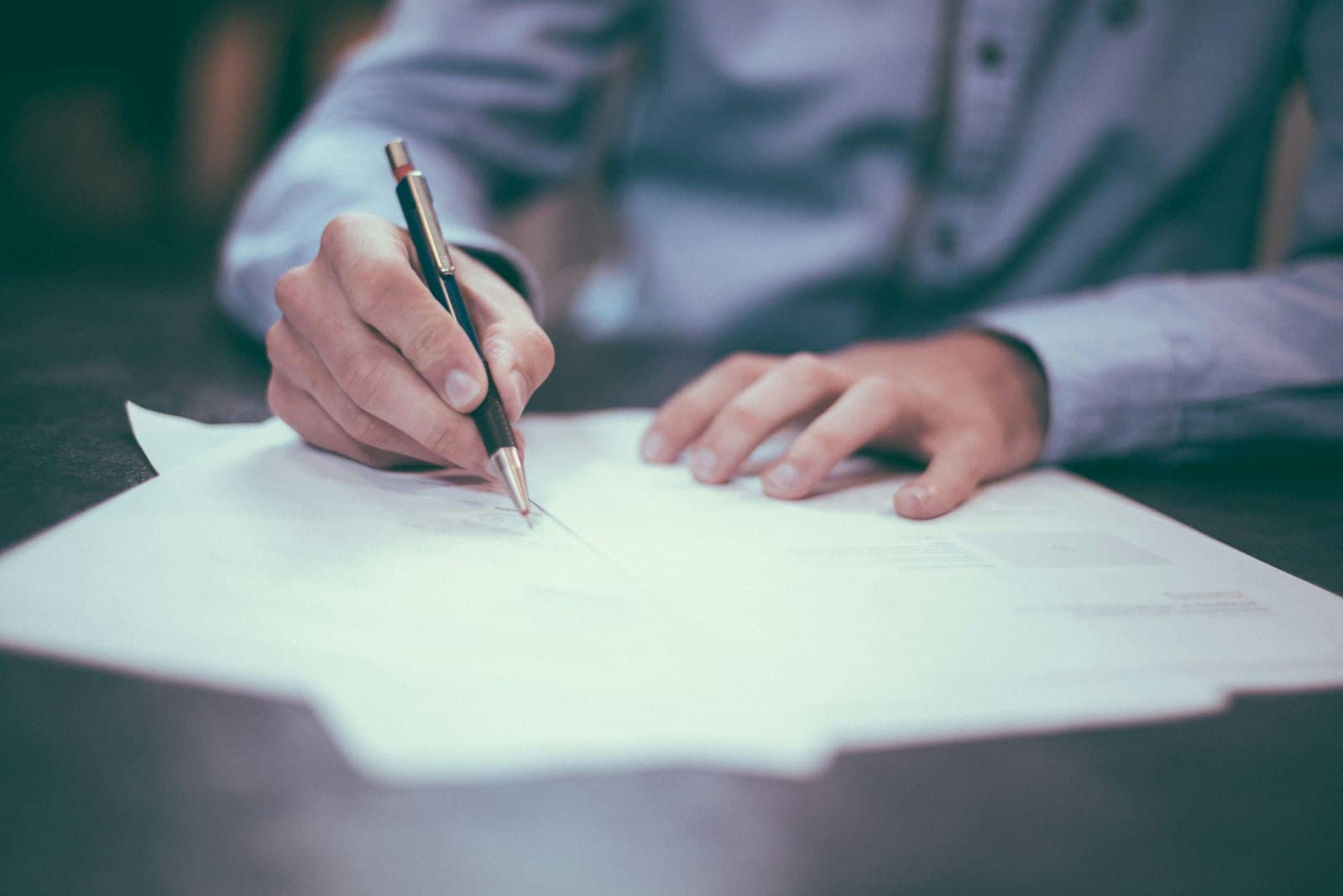 Signature d’un document lors d’un rendez-vous, symbole d’engagement et de confiance